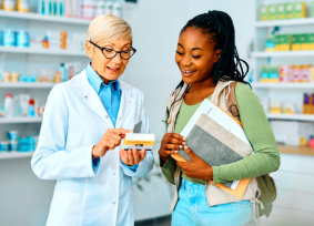 pharmacist and her patient talk regarding the vitamins